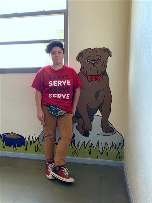 student posing with bulldog mural 